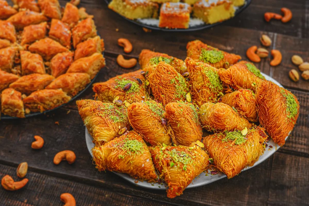 An assortment of baklava and kadayif pastries arranged on a platter