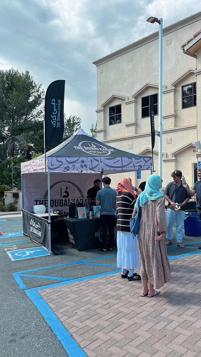 Guests being served karak chai at The Dubai Karak booth outside a community centre