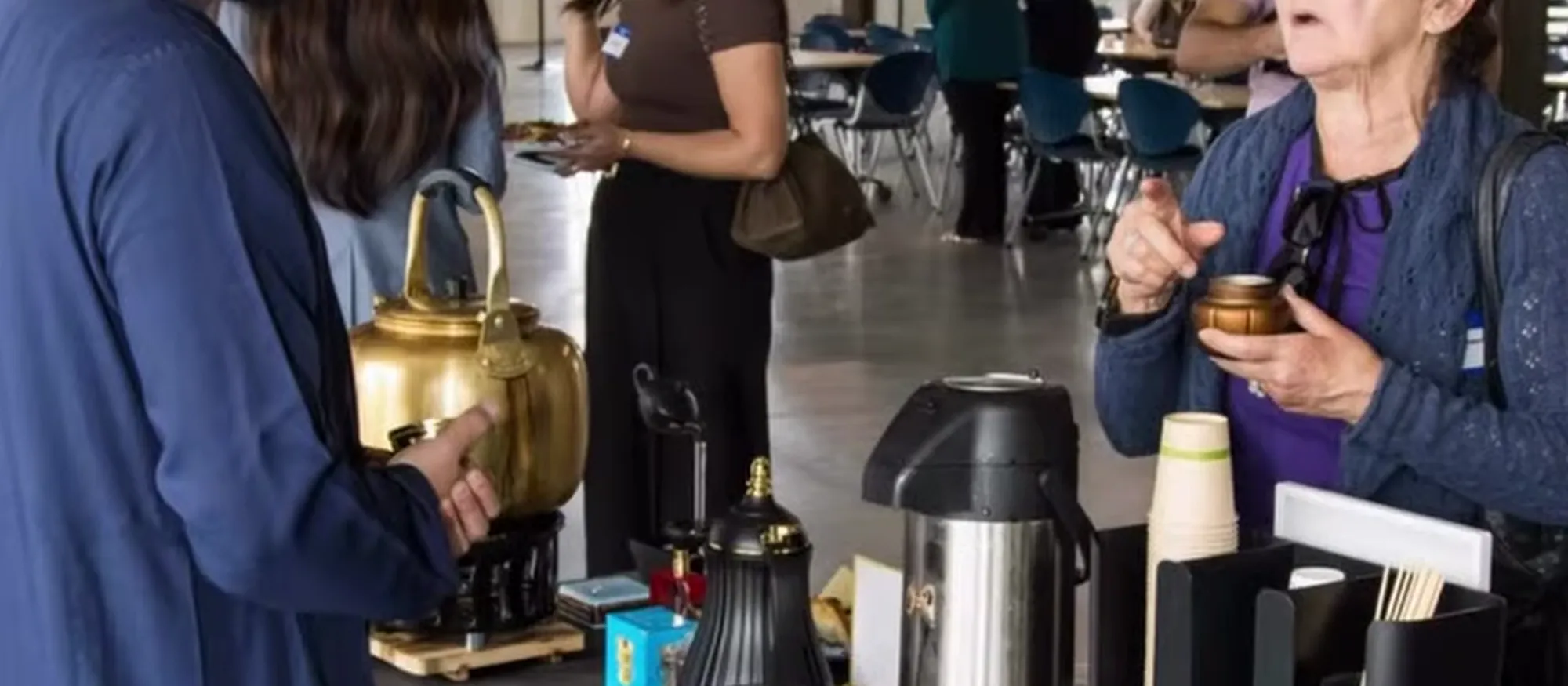 Guests served hot tea and coffee from The Dubai Karak counter at an indoor corporate event