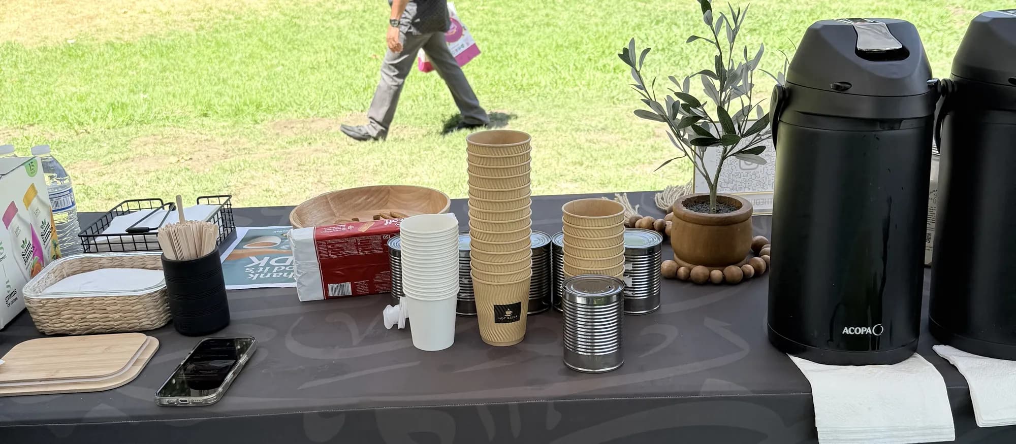 The Dubai Karak serving table at an outdoor park event with guests in the background