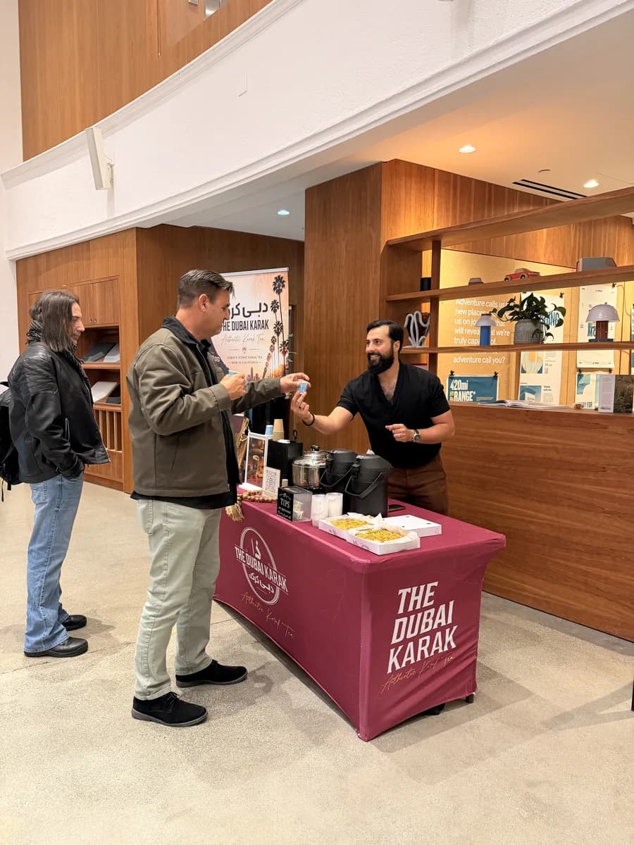 The Dubai Karak maroon branded counter serving guests inside an event venue